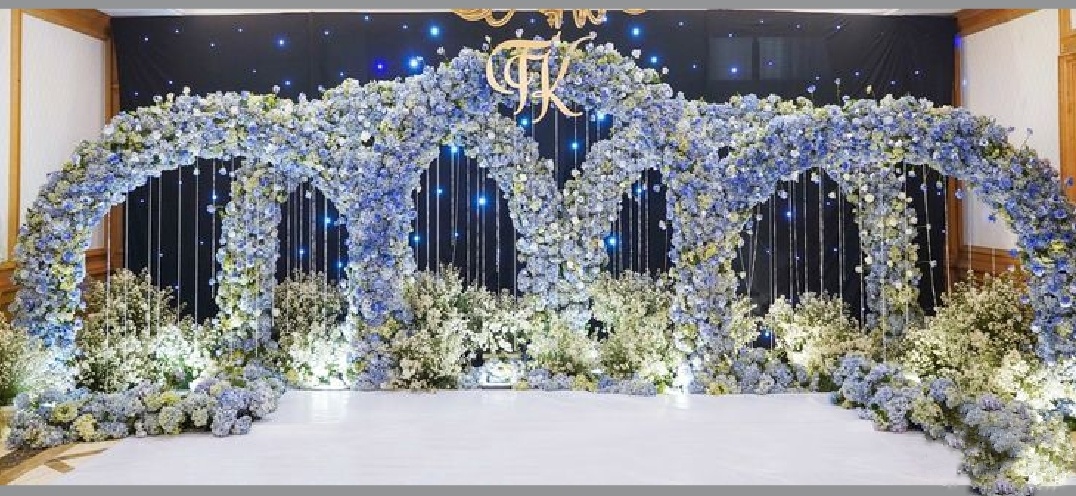 Elegant blue hydrangea arch stage decor with delicate floral arrangement for weddings and events.